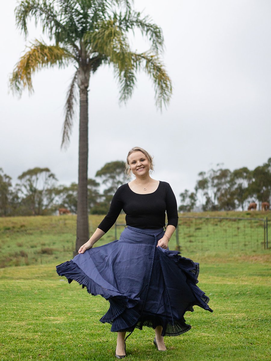 Anya Duggan walking in a paddock in a navy skirt